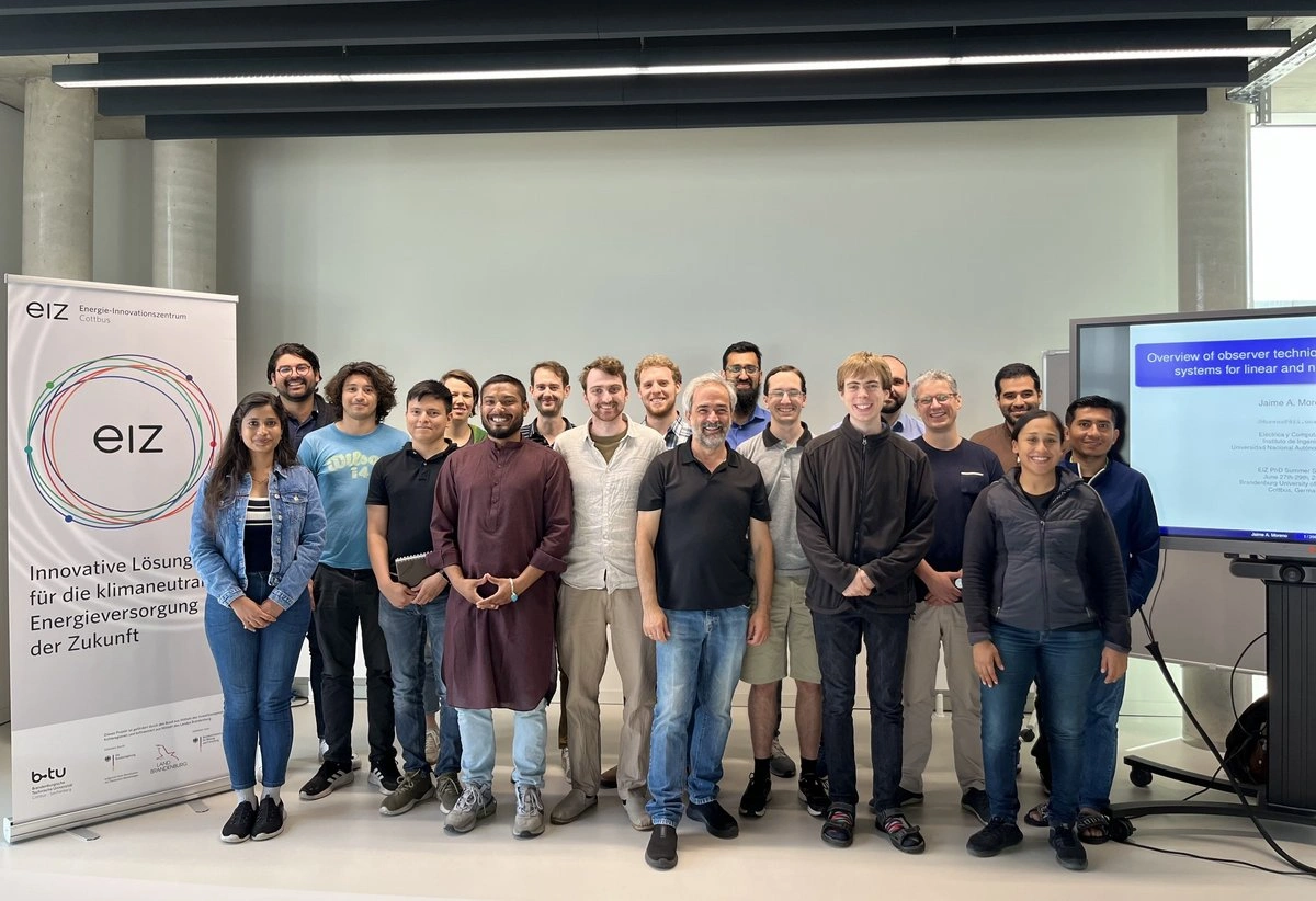 Zahlreiche Nachwuchswissenschaftler*innen mit dem Leiter der EIZ PhD Summer School, Prof. Jaime Moreno (UNAM) (mittig), sowie Prof. Dr.-Ing. Johannes Schiffer (rechts), Leiter des Fachgebiets "Regelungssysteme und Netzleittechnik" an der BTU-Cottbus Senftenberg | Foto: Friderike Lehmann, BTU