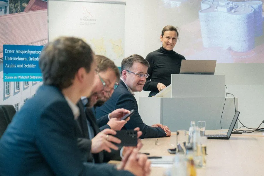Prof. Dr. Gesine Grande steht zusammen mit anderen Teilnehmenden der Wasserstofftour am EIZ.