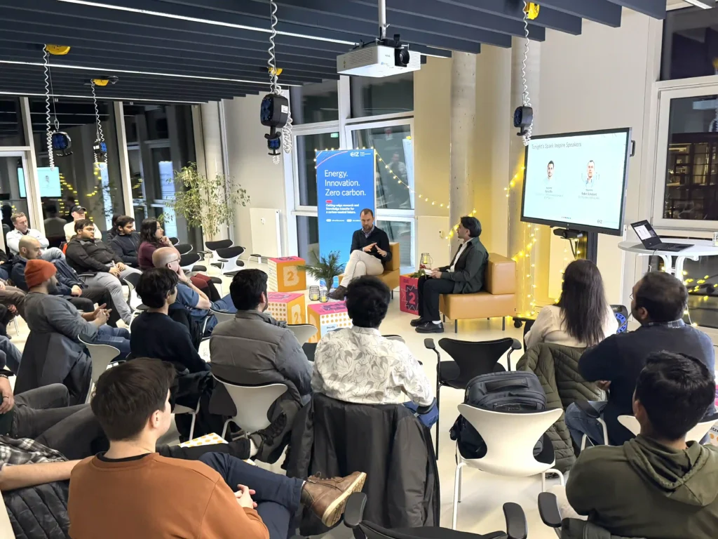 Menschen sitzen im Halbkreis vor einem Panel.